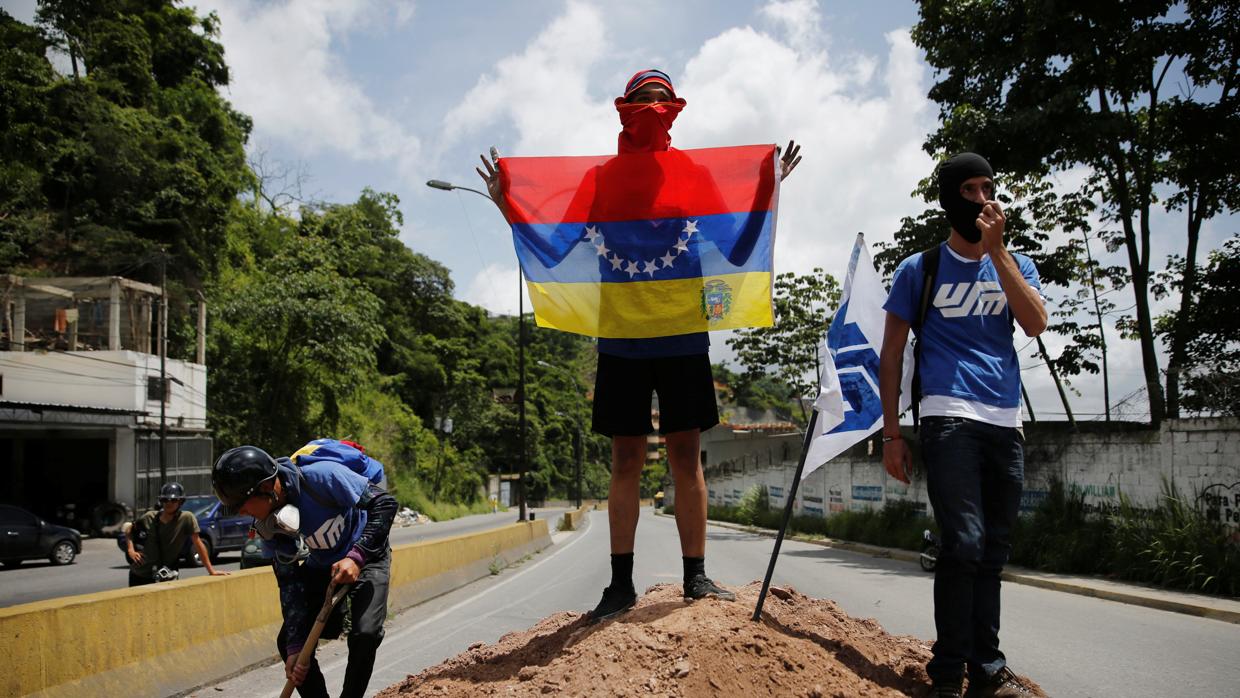 Un grupo de estudiantes cortan una carretera en protesta contra el régimen de Maduro