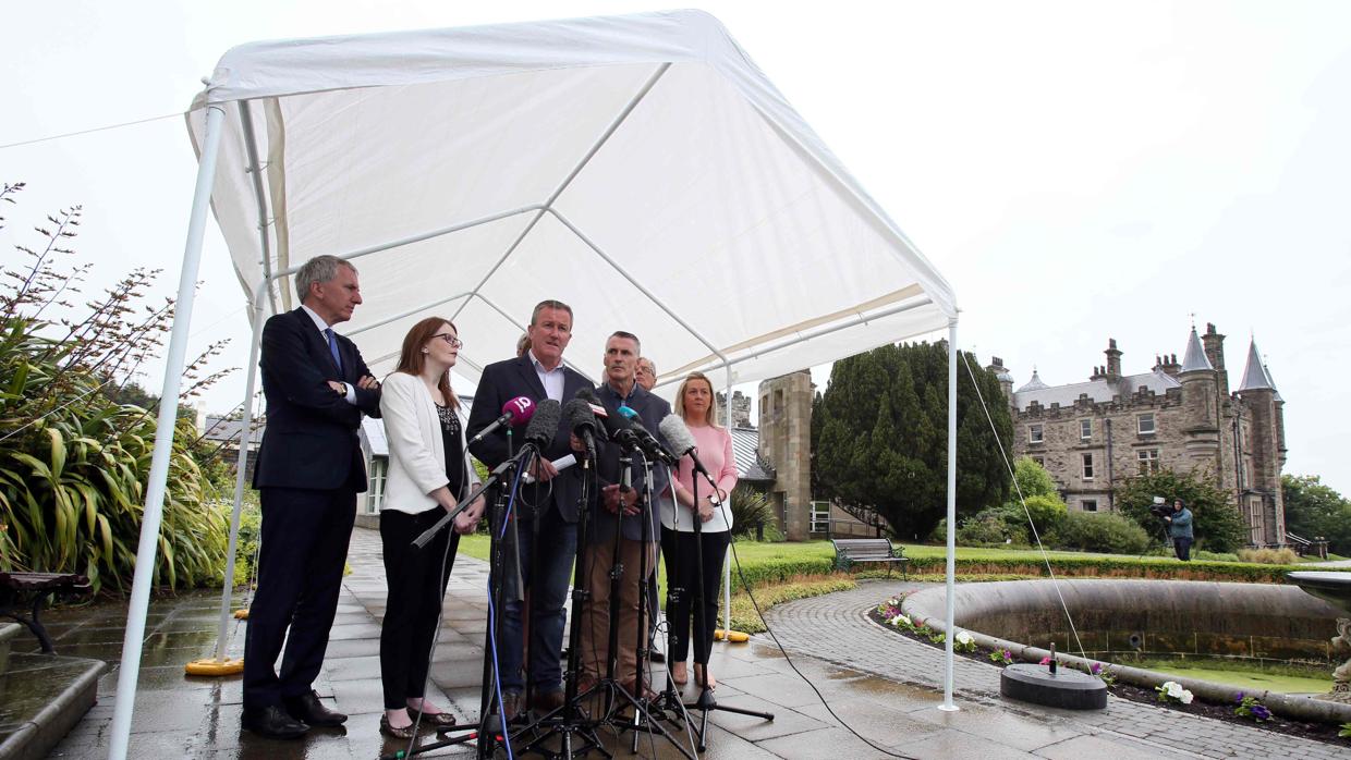 Conor Murphy, del Sinn Féin, flanqueado por otros miembros del partido, junto al castillo de Stormont