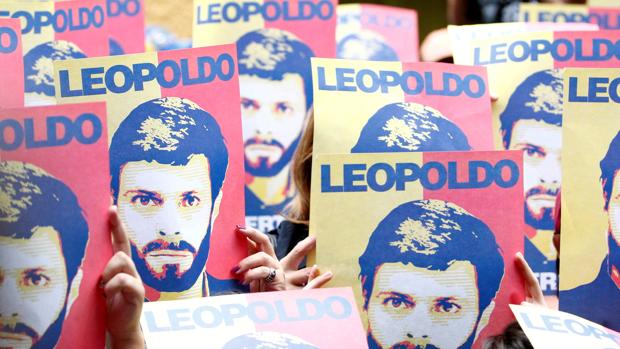 Seguidores de Leopoldo López sostiene unos carteles con su cara durante una manifestación