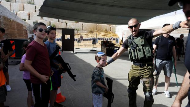 Un niño junto a un instructor israelí en el campo de entrenamiento para turistas