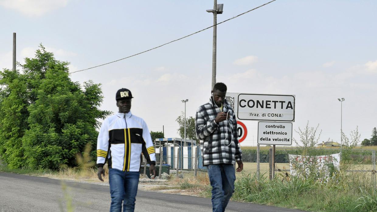 Los migrantes caminan por un sendero cerca del centro de acogida de Cona, cerca de Padua