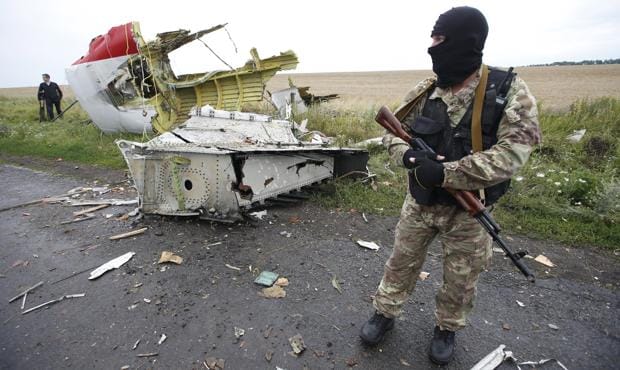 Un separatista prorruso permanece junto al los restos del avión que fue derribado por un misil de fabricación rusa el 17 de julio de 2014, el vuelo MH17 de Malaysia Airlines