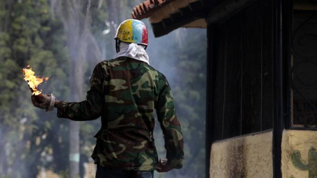 Un manifestante participa en la protesta que este martes se extendió por varias ciudades de Venezuela