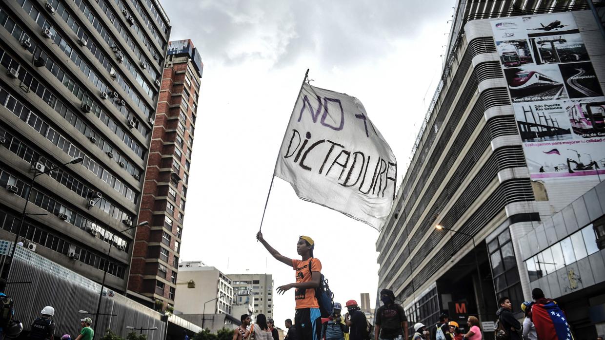 Un opositor sostiene una bandera contra el gobierno de Maduro