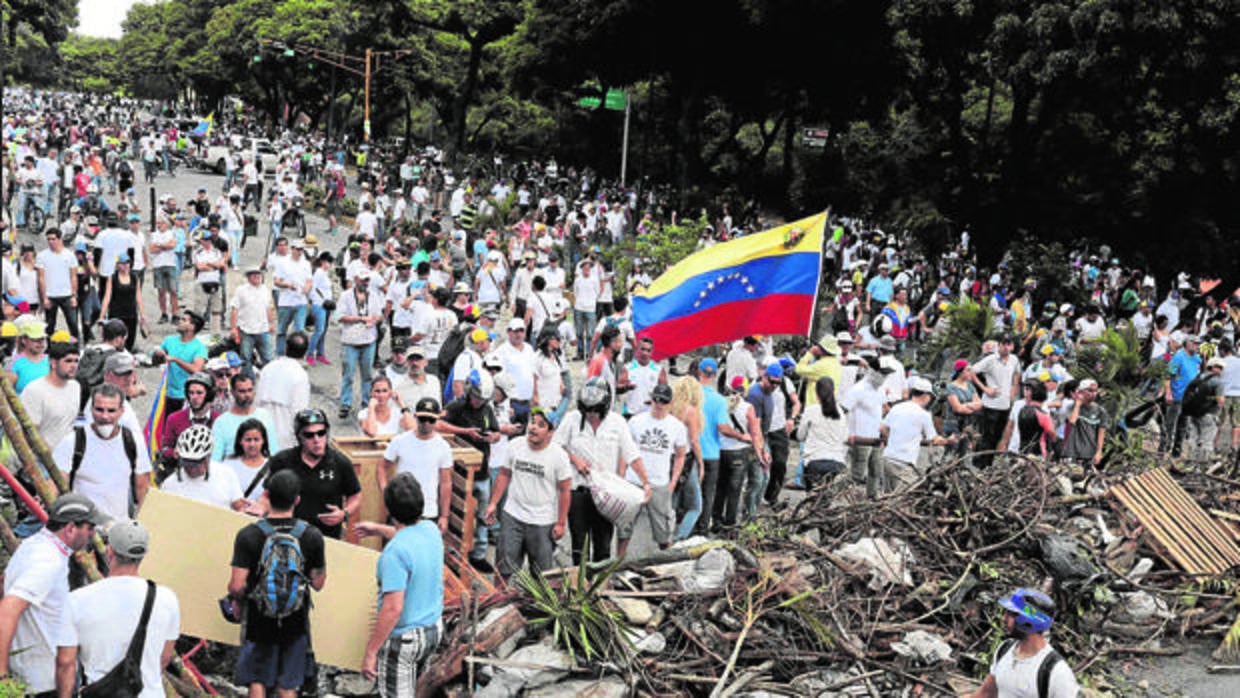 Manifestantes opositores tras una de las barricadas levantadas en Caracas