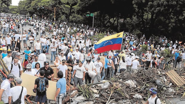 Manifestantes opositores tras una de las barricadas levantadas en Caracas