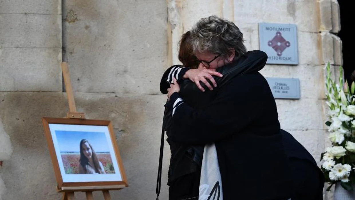 Familiares de una de las dos jóvenes asesinadas el domingo en Marsella, junto a su retrato, en Eguilles