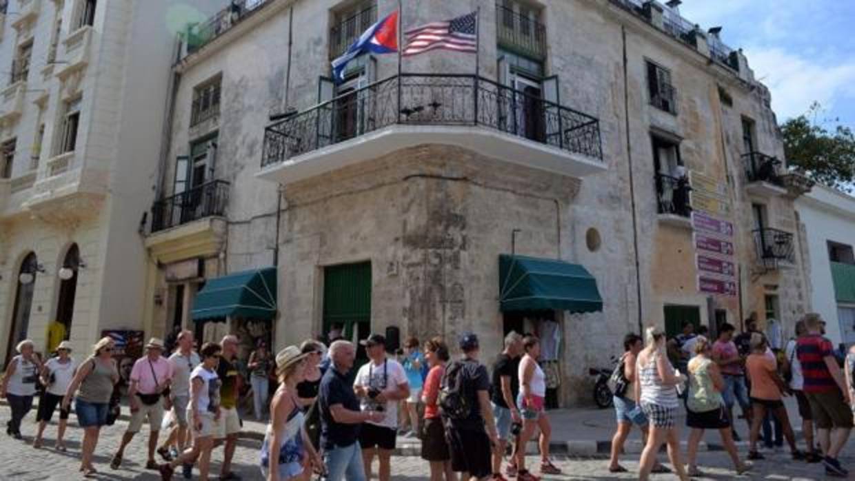 Un grupo de turistas junto a un edificio de La Habana con las banderas de EE.UU. y Cuba, poco antes del viaje de Barack Obama a la isla