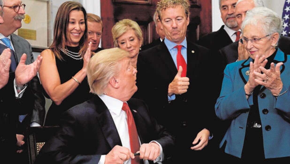 El senador Rand Paul le hace un gesto de apoyo a Trump tras la firma del decreto