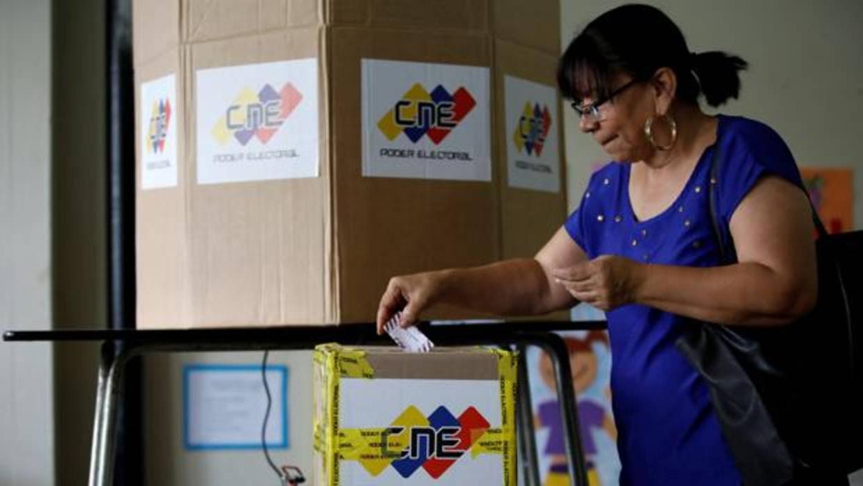 Una mujer deposita su voto en un centro electoral en Caracas