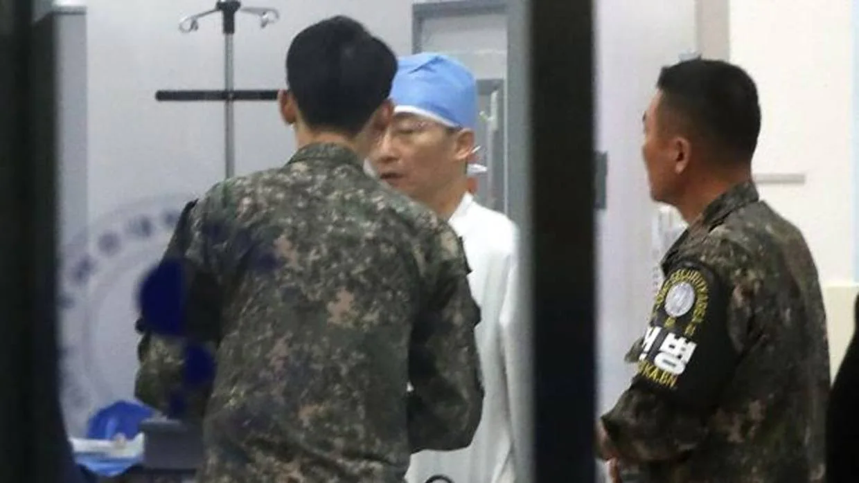 Militares surcoreanos, con brazaletes del Zona de Seguridad Conjunta de Panmunjom, hablan con un médico en un hospital en Suwon, al sur de Seúl
