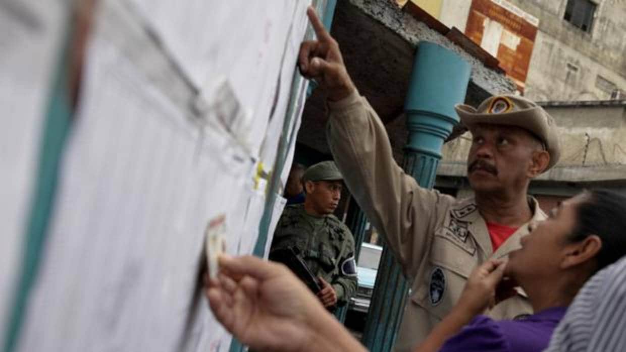 Electores comprueban su nombra en la lista de un colegio electoral en Caracas