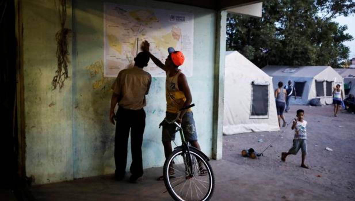 Venezolanos observan un mapa en un gimnasio de Boa Vista convertido en refugio