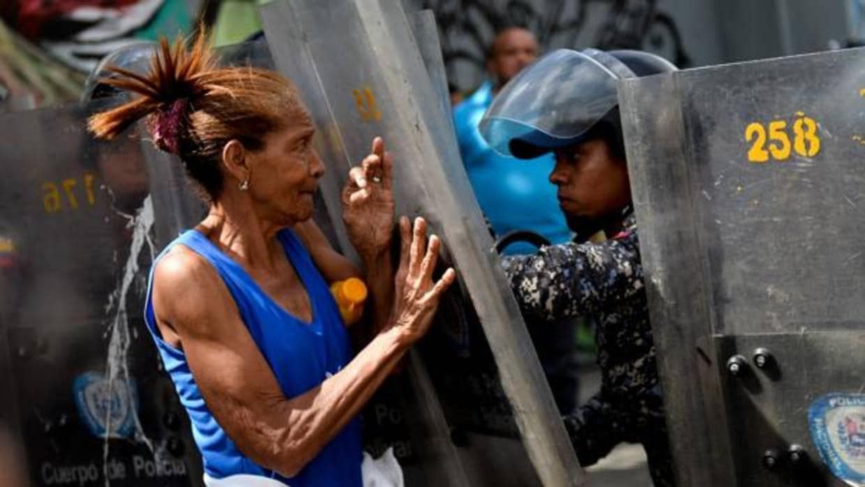 Una mujer se enfrenta a las fuerzas del orden durante una protesta por la falta de comida en Caracas