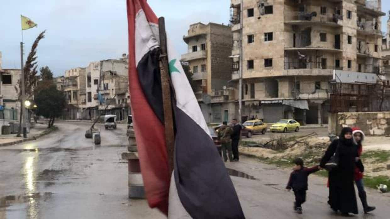 Entrada a Sheikh Mahsoud, el bastión de las YPG en Alepo. En primer término, la bandera del Ejército sirio, a la izquierda, detrás, la de las milicias kurdas