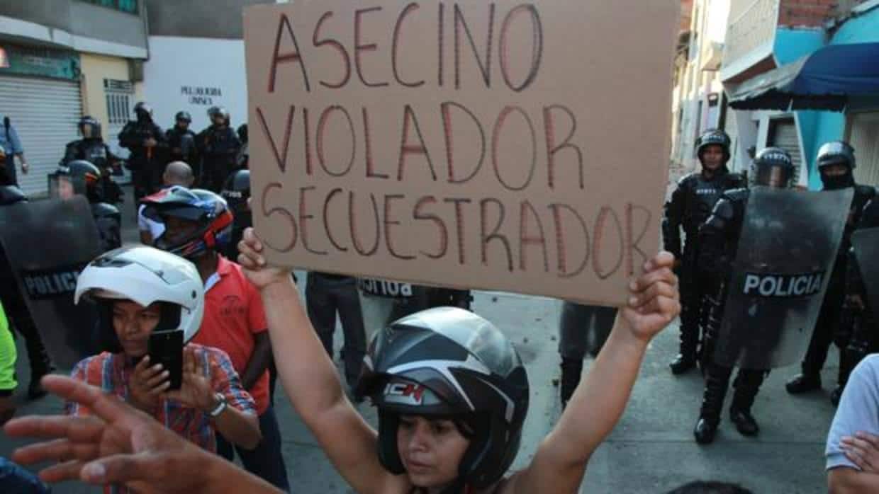 Una mujer muestra una pancarta contra Rodrigo Londoño en Yumbo, donde pretendía asistir a un acto de campaña