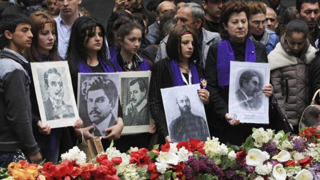 Armenios sostienen retratos de las víctimas durante una ceremonia conmemorativa por el centenario del genocidio armenio a manos del Imperio Otomano, en Yereván