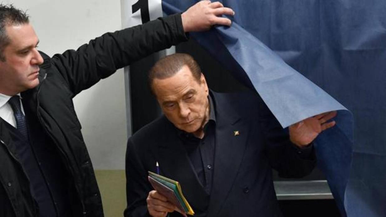 Silvio Berlusconi, sale da una cabina antes de depositar su voto para las elecciones el domingo en Milán