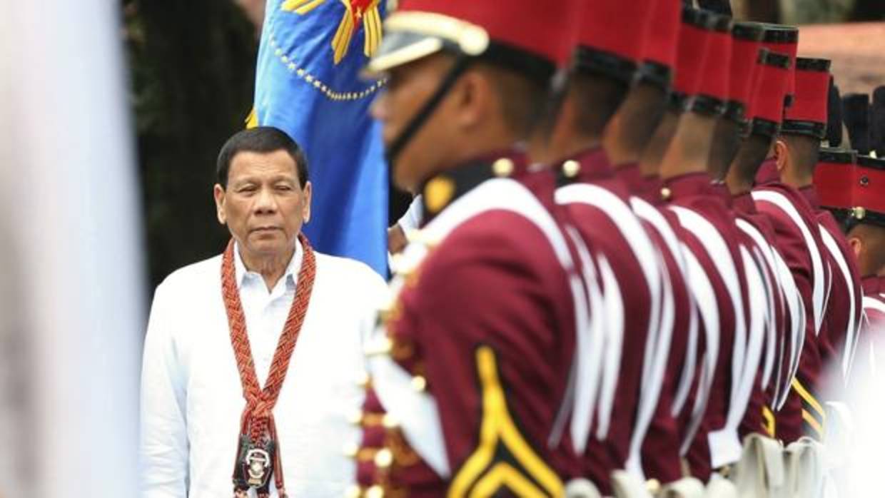 El presidente filipino, Rodrigo Duterte (izq), pasa revista a un grupo de cadetes durante su ceremonia de graduación en la base militar General Mariano Castañeda en la localidad de Silang (Filipinas)