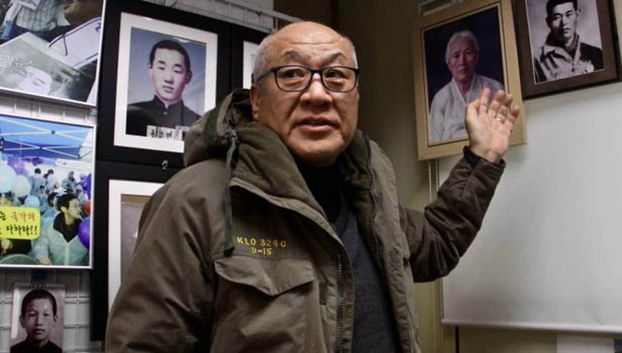 Choi Sung-yong enseña el retrato de su padre, raptado por el régimen estalinista de Pyongyang en 1967