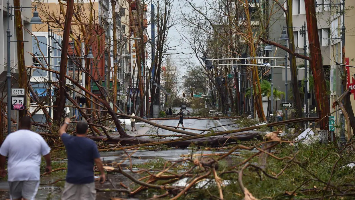 Dos hombres caminan por las calles de Puerto Rico después del paso del huracán María