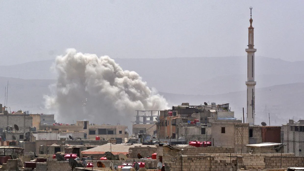 Columna de humo en el sur de la capital siria, Damasco, dende las fuerzas de Al Assad han bombardeado un enclave en manos de los rebeldes
