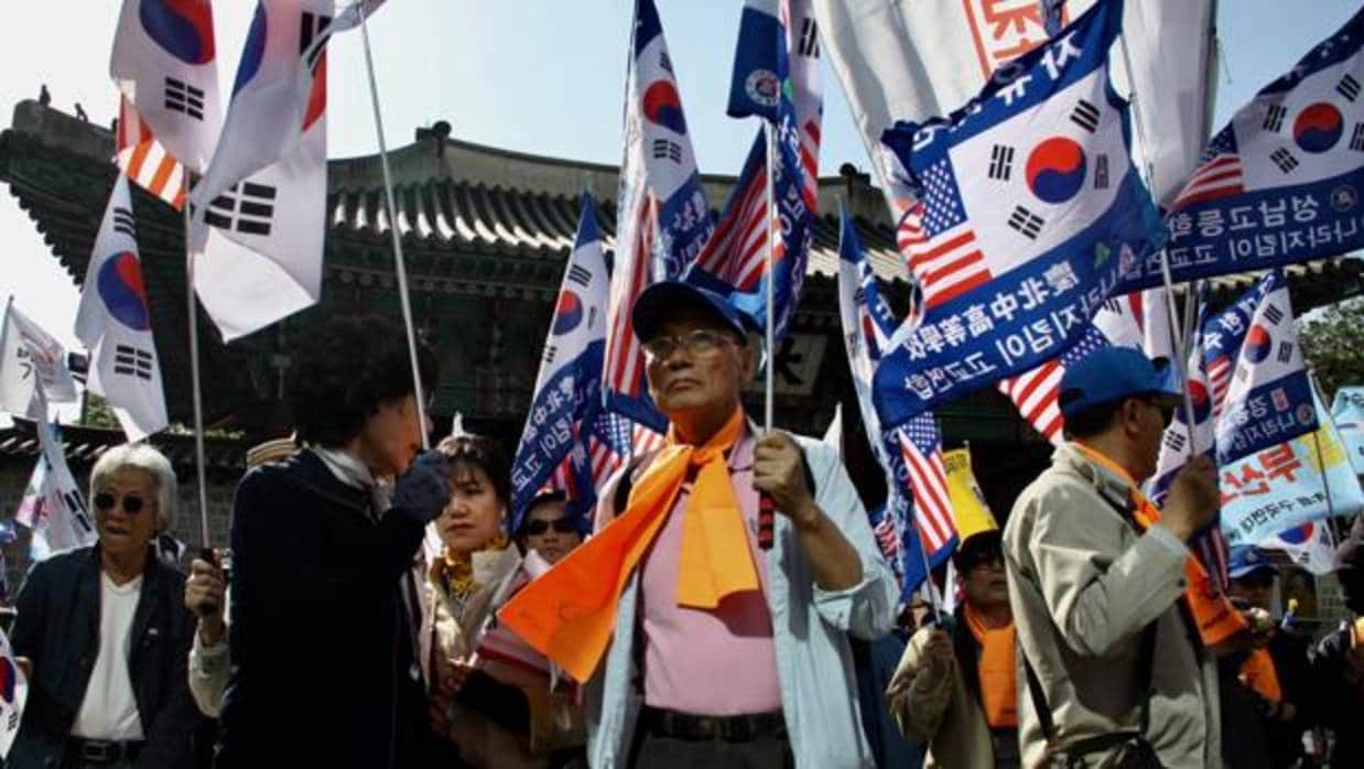 Desfilando al son de marchas militares, los manifestantes protestaron por el acercamiento a Corea del Norte