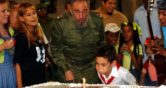 Fidel Castro y Elián González soplan juntos el pastel de cumpleaños del niño en 2003