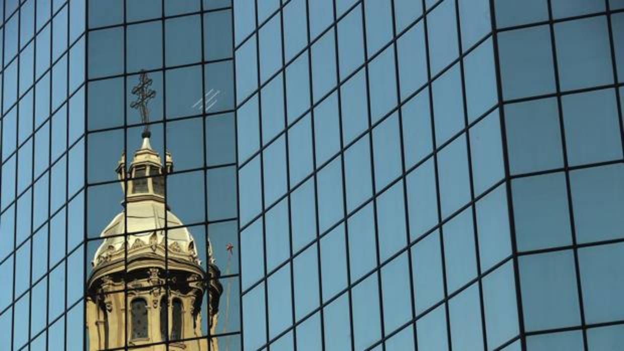 Vista de una de la cúpulas de la catedral de Santiago reflejada en un edificio