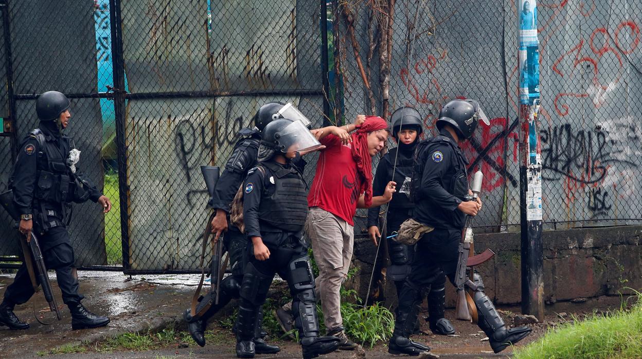 Agentes de la policía antidisturbios detienen a un manifestante durante una protesta contra el Gobierno