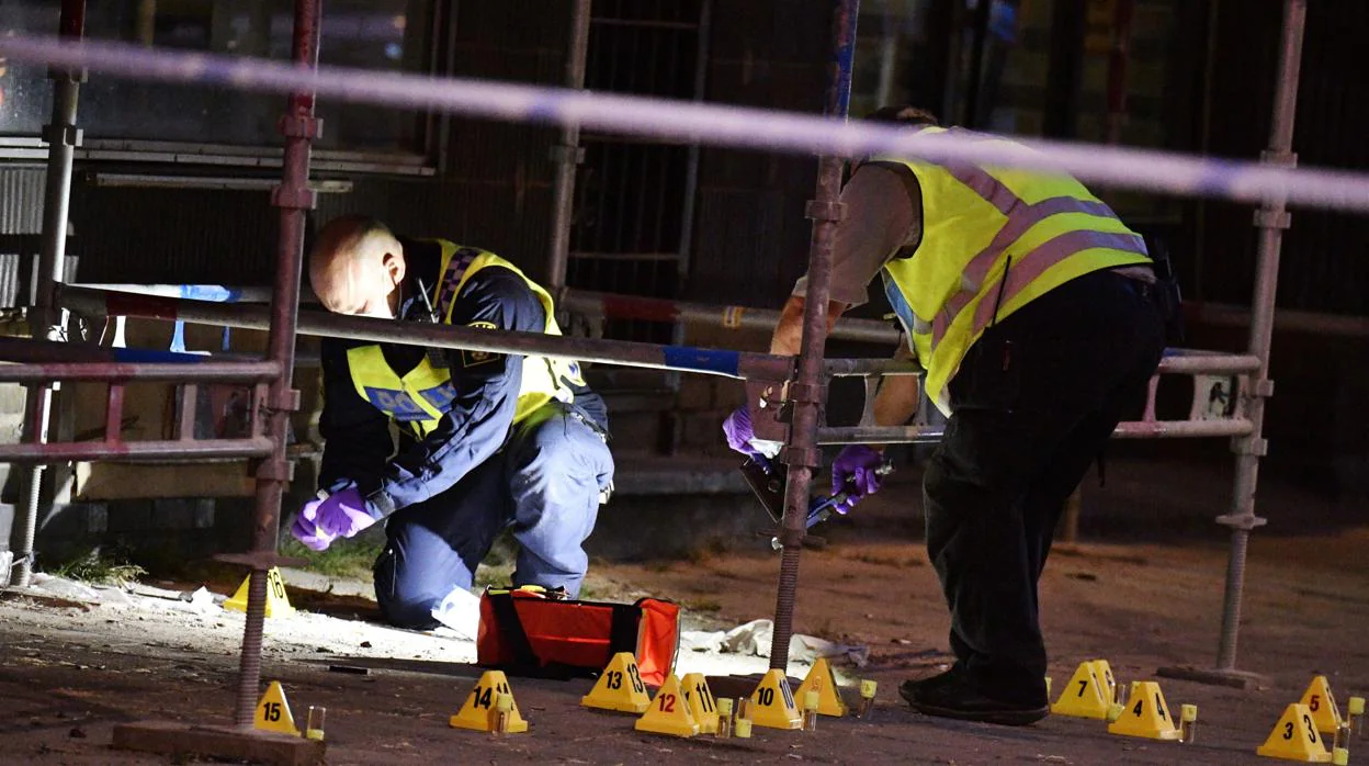 Policías forenses trabajan en el lugar en el que un grupo de personas resultaron heridas por arma de fuego en el centro de Malmo (Suecia)