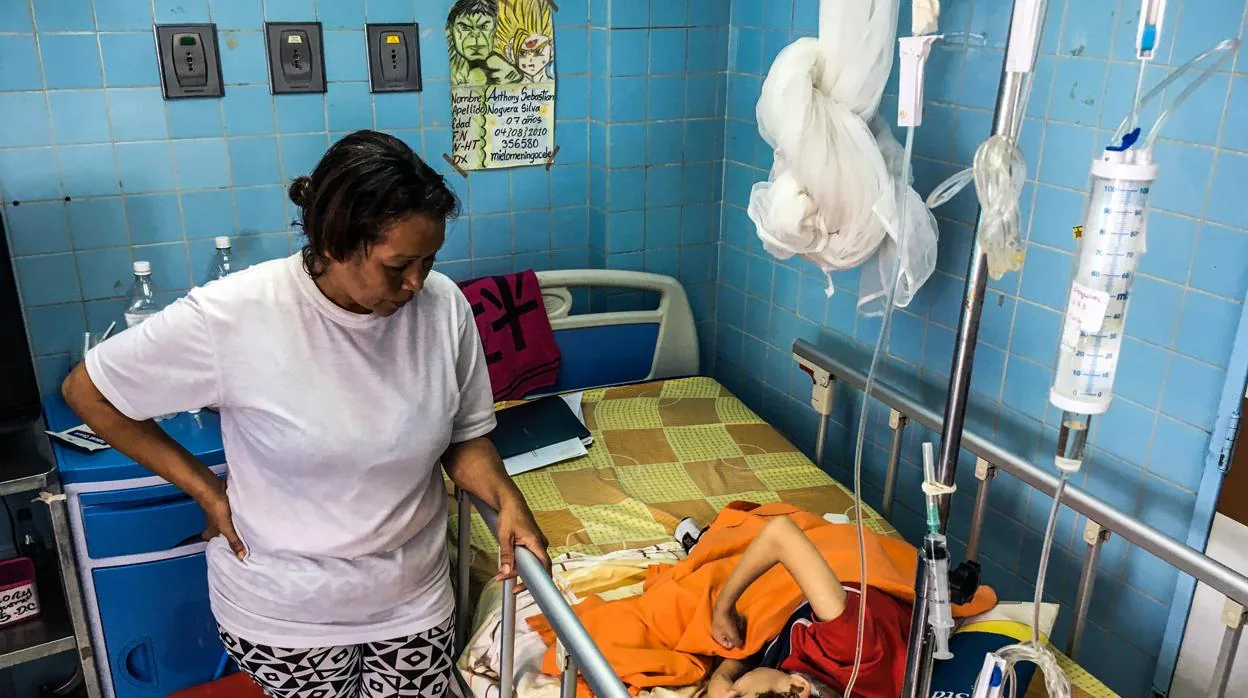 Una mujer, junto a su hijo en una sala de neurocirujía en el hospital infantil «Dr. JM de los Rios», en Caracas