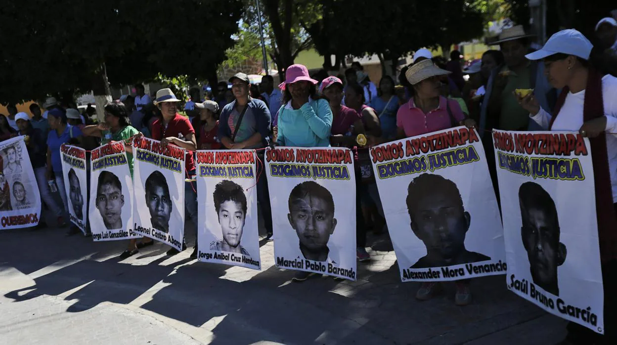 Familiares sostienen pancartas de los 43 estudiantes asesinados en 2014