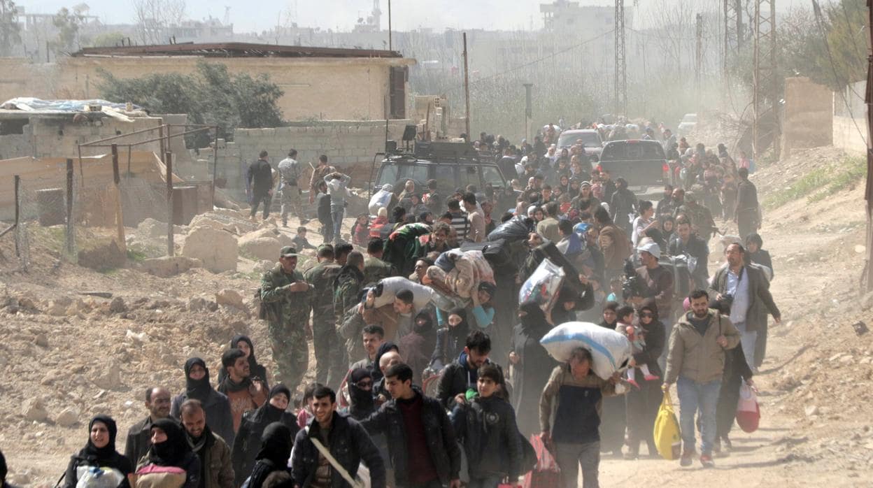Civiles abandonan la zona de Guta Oriental, en la zona rural de Damasco (Siria)