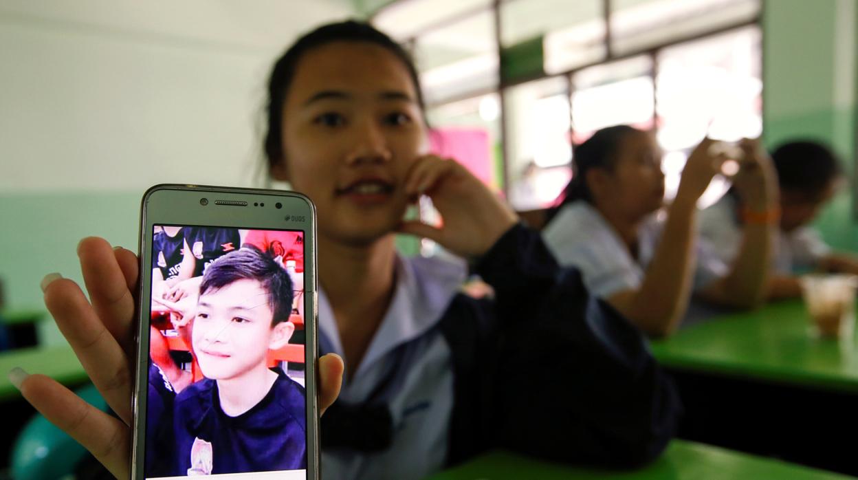 Una estudiante tailandesa muestra un retrato de su compañero de clase Duangpetch Promthep