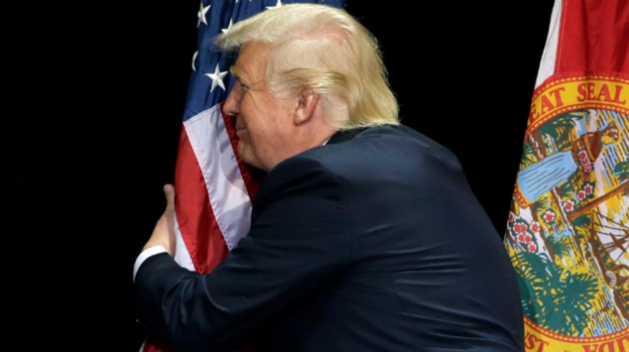 Donald Trump se abraza a una bandera de EE.UU. durante la campaña de 2016