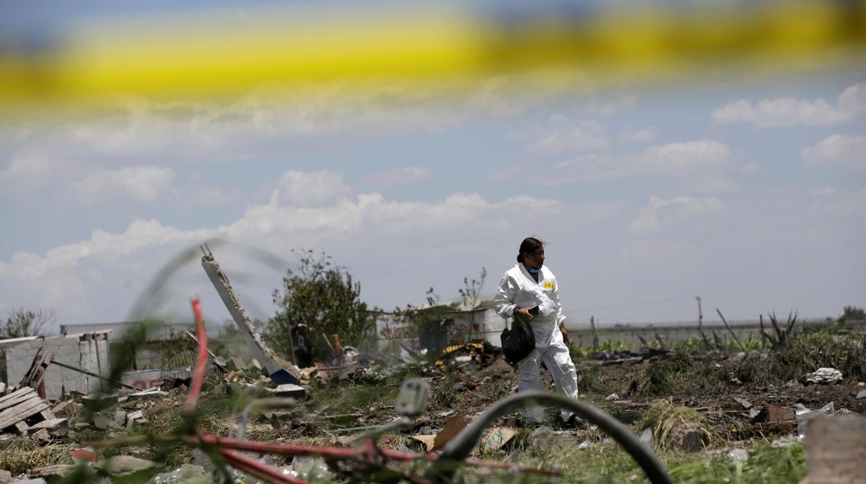 Técnico forense inspecciona la zona dañada por las explosiones en Tultepec