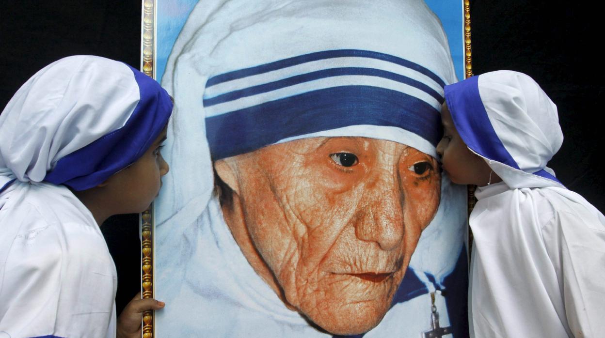 Dos Misioneras de la Caridad besan un retrato de la Madre Teresa de Calcuta
