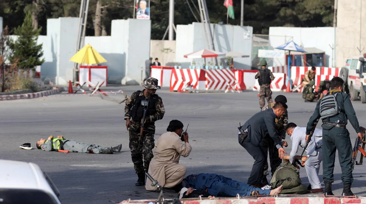 En los alrededores del aeropuerto de Kabul, las fuerzas de seguridad ayudan a los heridos