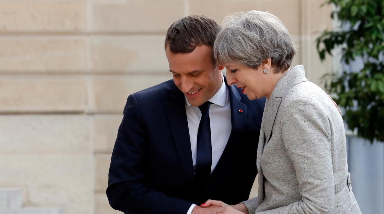 Emmanuel Macron saluda a Theresa May antes de una cena de trabajo en el Palacio del Elíseo en París