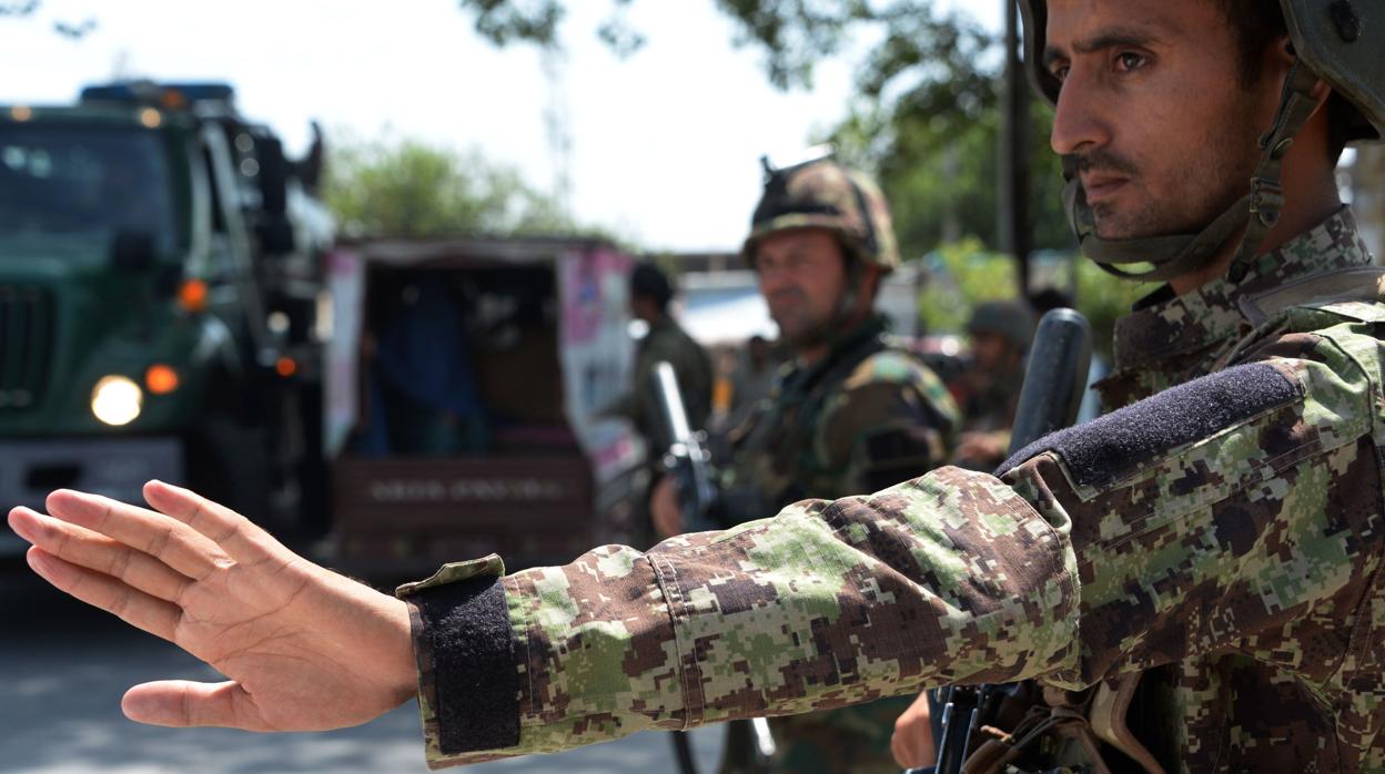 Soldados del Ejército Nacional Afgano registran vehículos en un puesto de control en Jalalabad