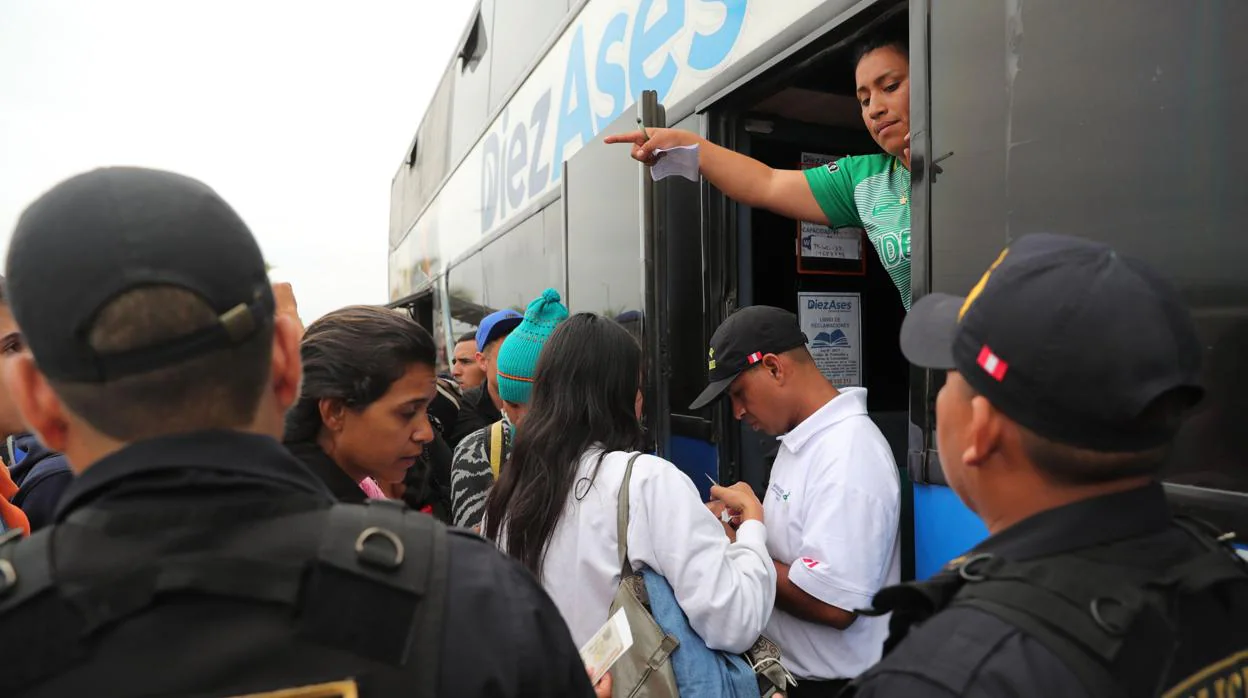 Inmigrantes venezolanos presentan sus documentos al subir a un bus que los llevará a Trujillo desde el Centro Binacional de Atención en Frontera (Cebaf) en Tumbes (Perú)