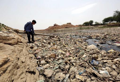 Un niño yemení está rodeado de residuos y desechos, entorno de alto riesgo para el cólera
