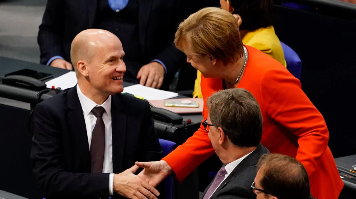 La canciller alemana, Angela Merkel (d), saluda al recién elegido jefe del grupo parlamentario conservador CDU/CSU, Ralph Brinkhaus (i)