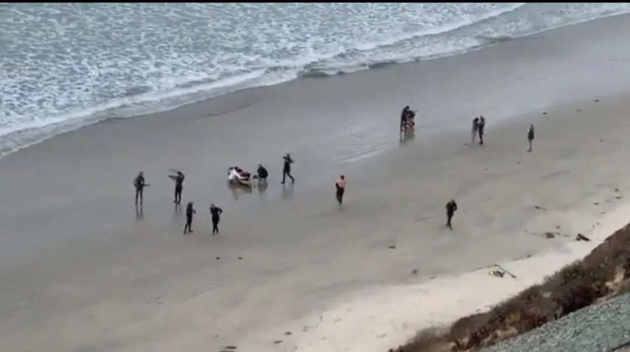 Bañistas atienden al niño de 13 años al que mordió un tiburón en Beacon's Beach, en California, el pasado sábado
