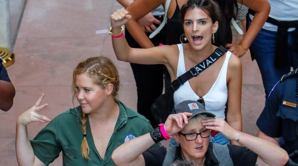 La actriz Amy Schumer y la modelo Emily Ratajkowski realizan un gesto tras ser detenidas junto a 302 mujeres