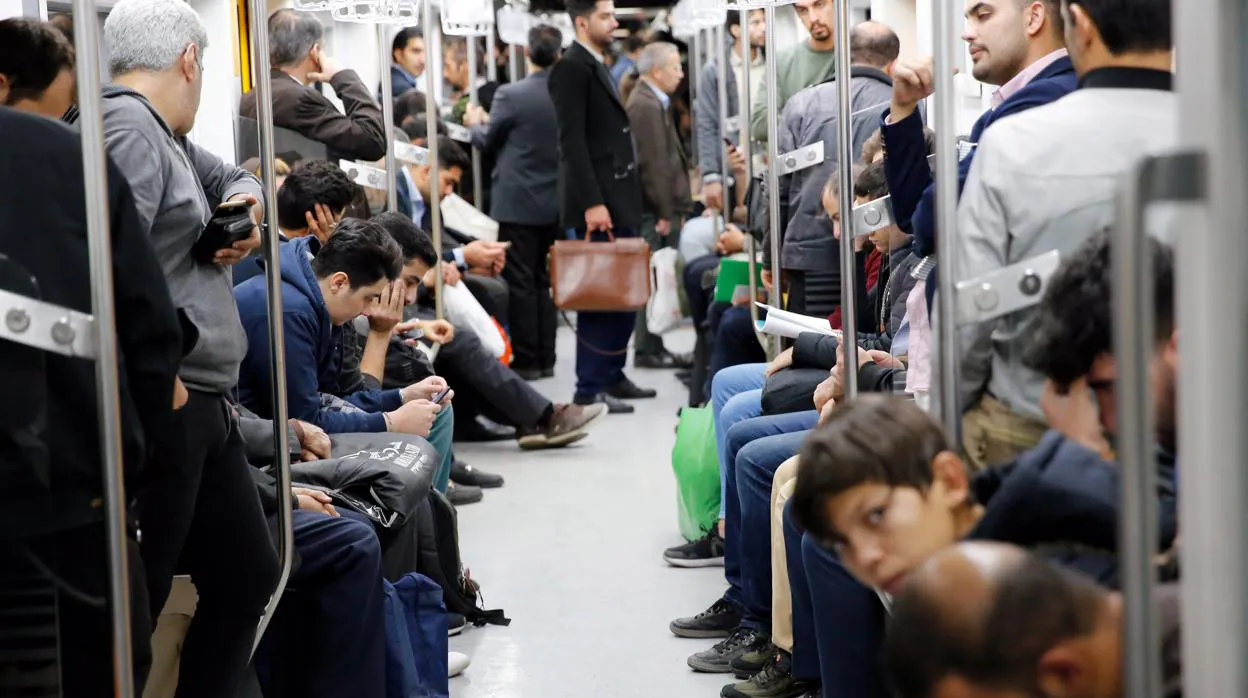 Varias personas viajan en tren en Teherán
