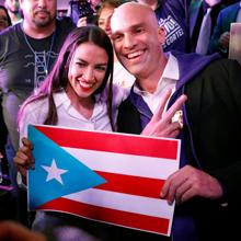 Ocaso-Cortez posa con una bandera puertorriqueña junto a un seguidor