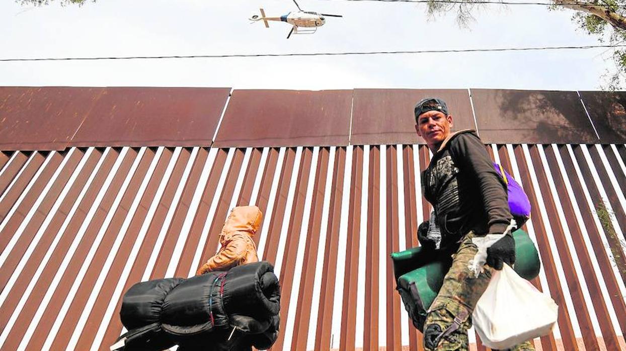 Miembros de la caravana continúan llegando al norte de México. Un helicóptero de la patrulla fronteriza de Estados Unidos sobrevuela la valla fronteriza
