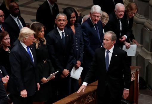 El expresidente George W. Bush pasa por delante del banco donde se encuentran los otros exmandeatarios y el actual presidente, Donald Trump
